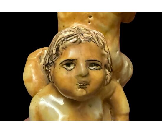 Scultura in maiolica policroma con due fanciulli che reggono un fauno.Nicola Giustiniani.Napoli.