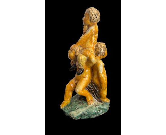 Scultura in maiolica policroma con due fanciulli che reggono un fauno.Nicola Giustiniani.Napoli.