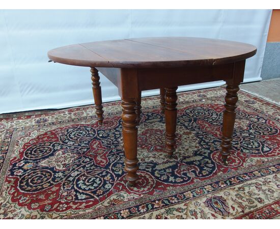 ROUND EXTENDABLE TABLE IN WALNUT, 19th CENTURY. L129xW131xH74 cm. Total extension 370 cm