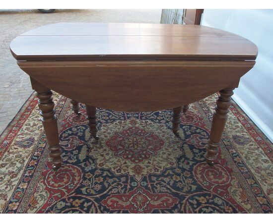 ROUND EXTENDABLE TABLE IN WALNUT, 19th CENTURY. L129xW131xH74 cm. Total extension 370 cm
