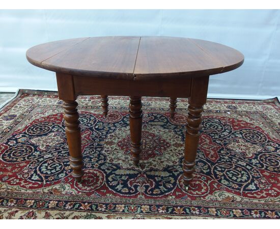 ROUND EXTENDABLE TABLE IN WALNUT, 19th CENTURY. L129xW131xH74 cm. Total extension 370 cm