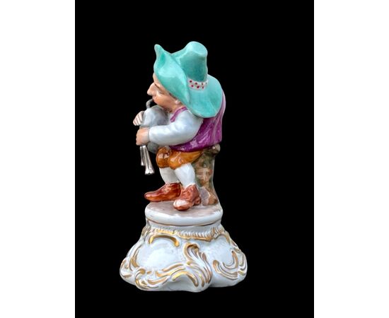Figura di gobbo in porcellana che suona zampogna. Manifattura Fabris.Milano.
