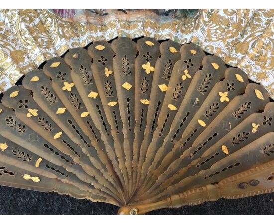 Fan in pierced and gilded tortoiseshell with paper sheet featuring watercolor prints with gallant scenes.
