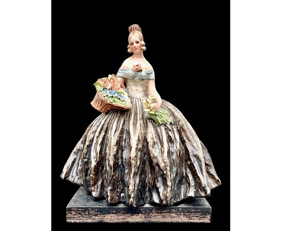 Figura femminile con cesto di fiori.Manifattura di Guido Cacciapuoti.Milano.