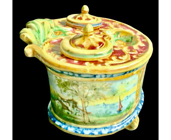 Calamaio in maiolica a 4 piedi con presa a forma di foglia e decoro con medaglioni con paesaggi e personaggi.Manifattura Minghetti.Bologna.