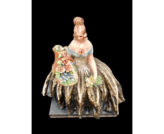 Figura femminile con cesto di fiori.Manifattura di Guido Cacciapuoti.Milano.