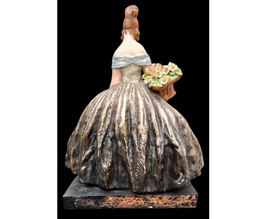 Figura femminile con cesto di fiori.Manifattura di Guido Cacciapuoti.Milano.