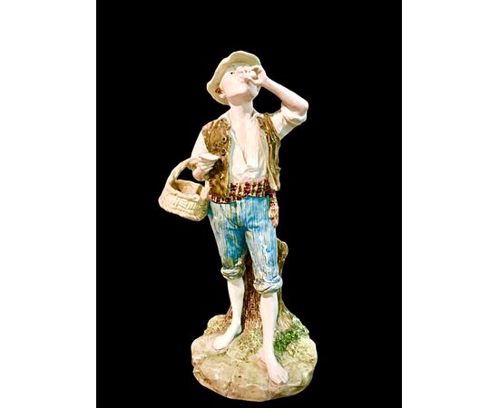 Polychrome majolica sculpture depicting a peasant drinking eggs. Ginori.