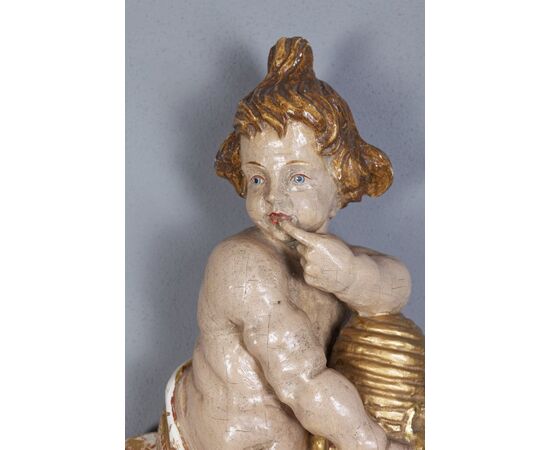 Scultura in legnio "Putto degustando miele"
