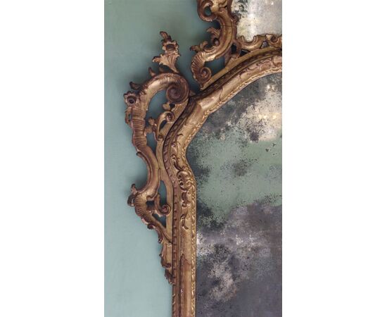Carved, sculpted, and gilded wooden mirror. Venice, mid-18th century.