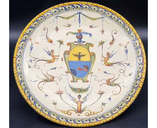 Grande piatto da parata in maiolica decorata a grottesche, con stemma nobiliare – Italia centra