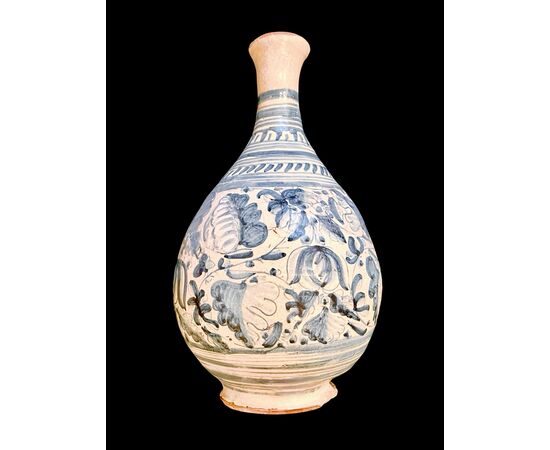 Majolica bottle with turquoise monochrome decoration depicting stylized plant motifs. Montelupo.