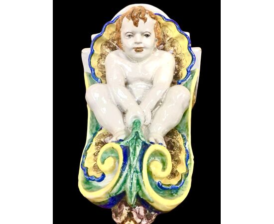 Pair of majolica shelves with cherubs and shell motifs. Rubbiani manufacture of Sassuolo.