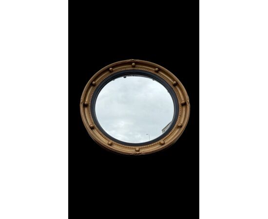 Specchio convesso ‘occhio della strega’ con cornice in legno dorato.