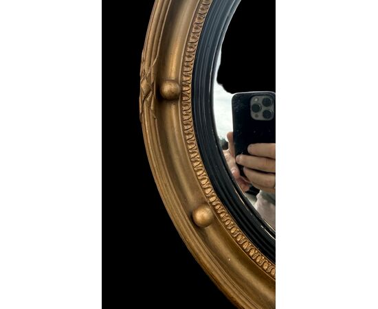 Specchio convesso ‘occhio della strega’ con cornice in legno dorato.