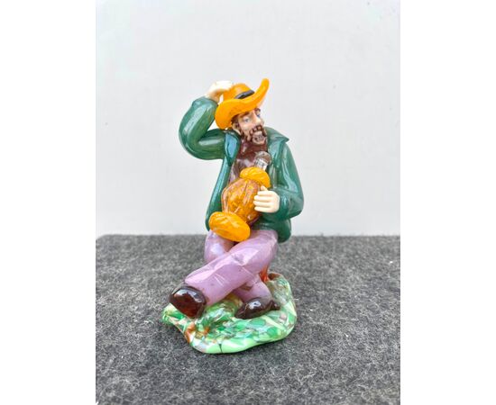 Glass sculpture depicting a seated character with a flask of wine, Bohemia.     