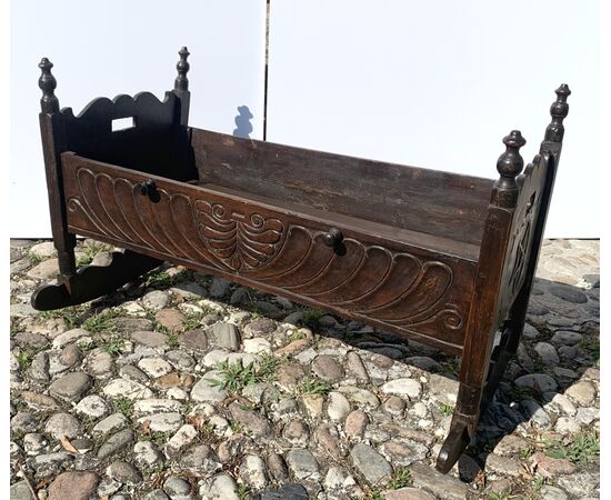 Culla in legno intagliato. Italia, XIX secolo.