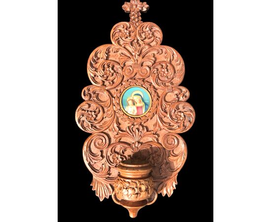 Acquasantiera in legno scolpito con motivi vegetali stilizzati e miniatura.Madonna con Bambino.