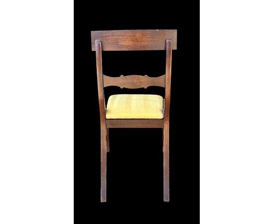 Four walnut chairs with geometric pattern decoration.