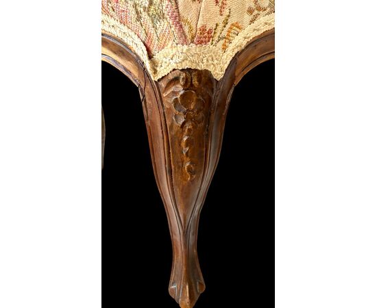 Four walnut chairs with floral pattern carvings.