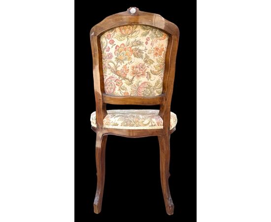 Four walnut chairs with floral pattern carvings.
