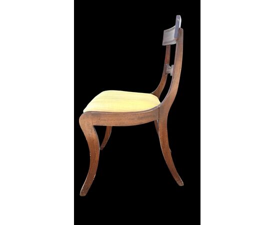 Four walnut chairs with geometric pattern decoration.