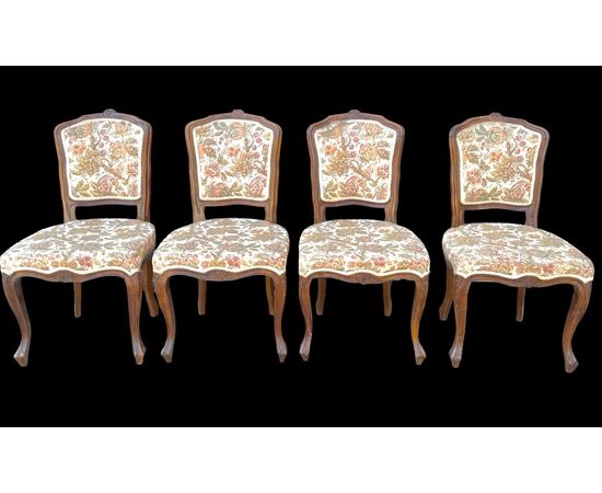 Four walnut chairs with floral pattern carvings.