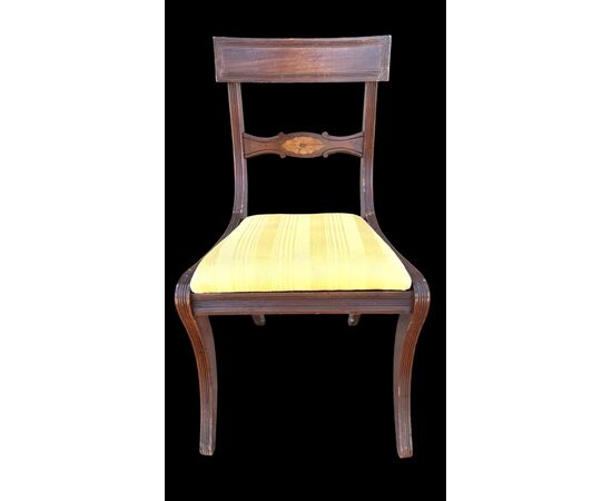Four walnut chairs with geometric pattern decoration.