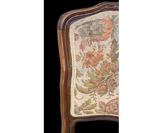 Four walnut chairs with floral pattern carvings.