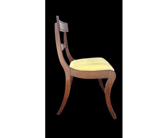 Four walnut chairs with geometric pattern decoration.