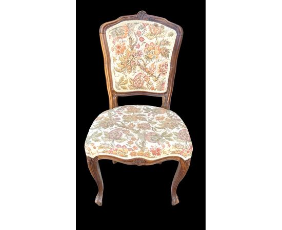 Four walnut chairs with floral pattern carvings.