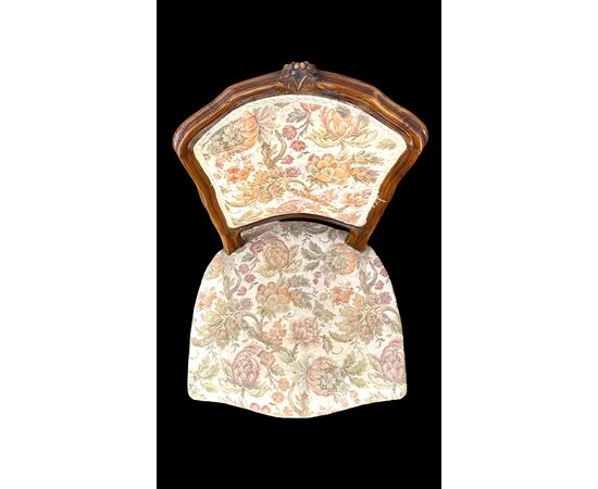 Four walnut chairs with floral pattern carvings.