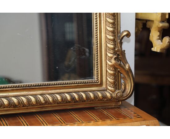 Specchiera in legno dorato ed intagliato con cimasa a ricciolo metà 800