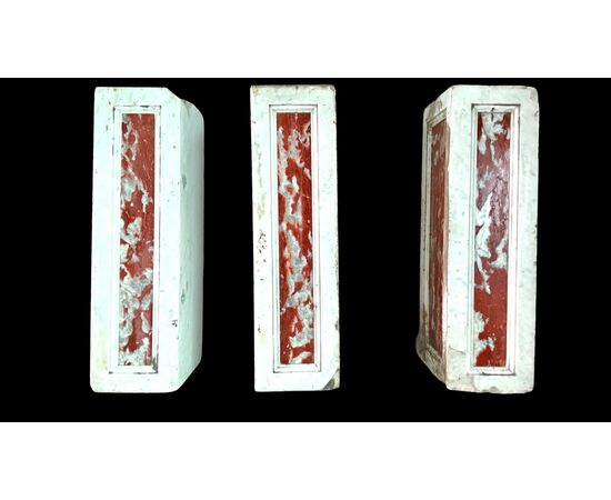 Three architectural elements in marble with a white frame and a variegated red central section.