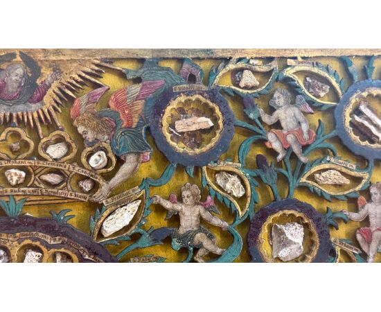 Quadro reliquiario con composizione in legno traforato in rilievo con putti e motivi vegetali. Quadro reliquiario con composizione in legno traforato in rilievo con putti e motivi vegetali.