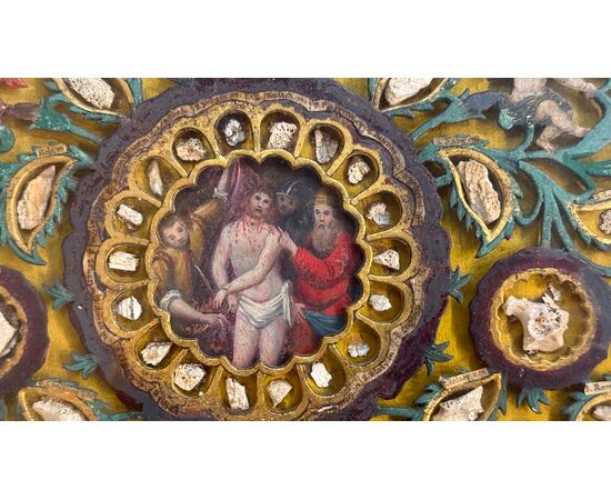 Reliquary painting with openwork wood composition in relief with putti and vegetal motifs. Reliquary painting with openwork wood composition in relief with putti and vegetal motifs.