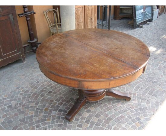 Large round table in walnut with a central leg     