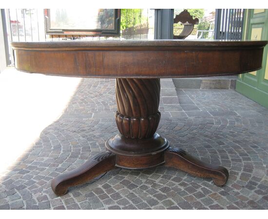 Large round table in walnut with a central leg     