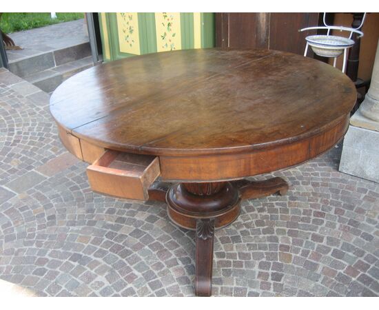 Large round table in walnut with a central leg     