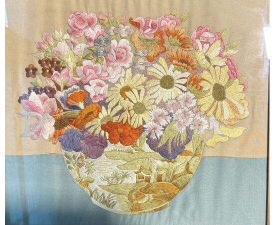 Framed panel with vase of flowers embroidered on fabric.