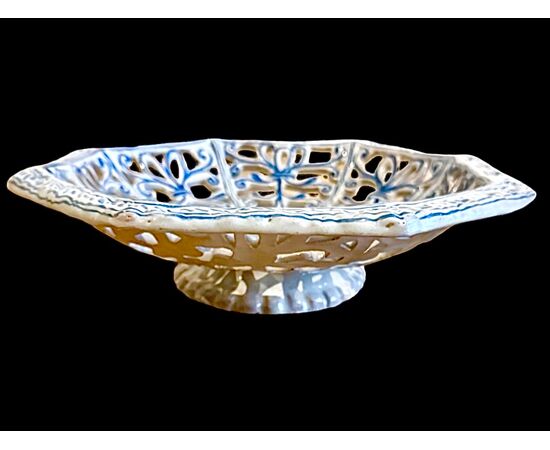 Octagonal raised plate in pierced majolica with geometric motifs and architectural scene in the center. Savona.