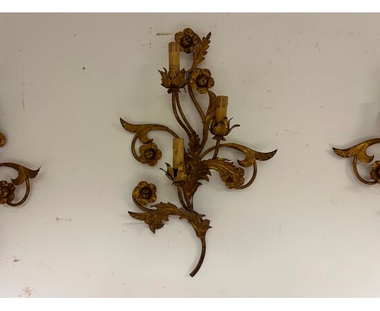 Three gilded metal sconces with floral motifs. 19th century