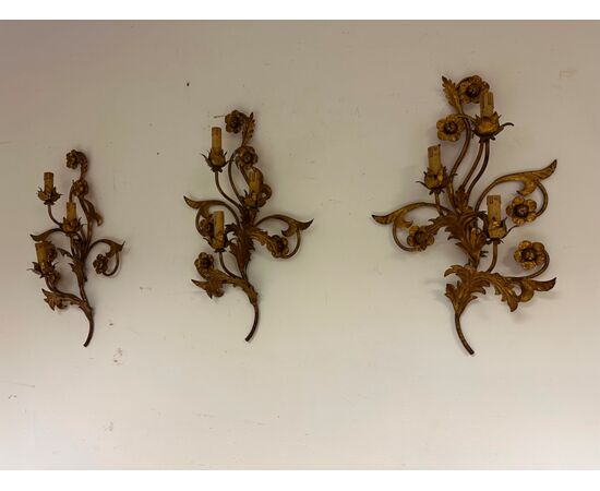 Three gilded metal sconces with floral motifs. 19th century