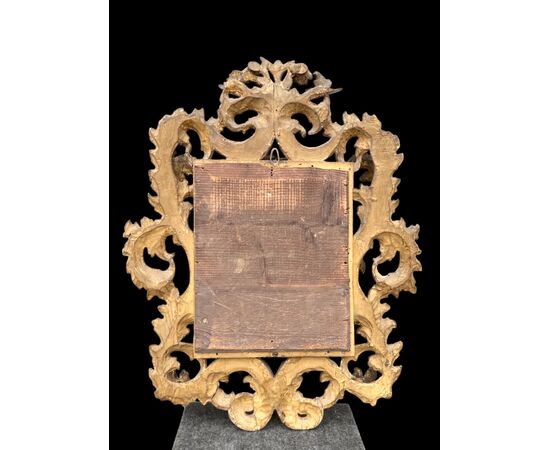 Carved and gilded wooden frame-mirror with 'cartoccio' decoration.