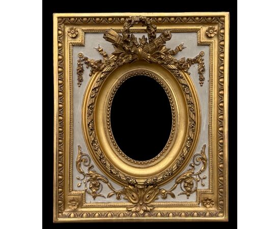 Cornice in legno intagliato con trofei,ghirlande,motivi vegetali e geometrici.