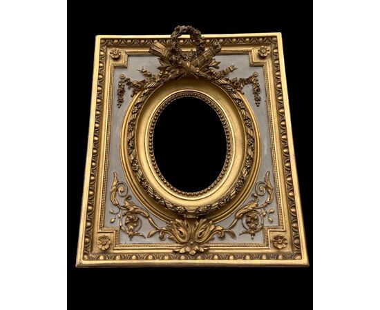 Cornice in legno intagliato con trofei,ghirlande,motivi vegetali e geometrici.