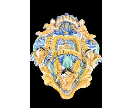 Acquasantiera in maiolica con putti e motivi vegetali stilizzati.Ariano Irpino.