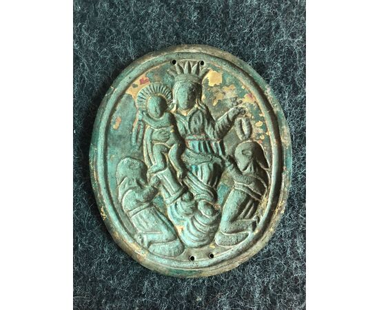 Brass tablecloth depicting the Madonna with Child and two hooded characters. Brotherhood of the Rosary.     