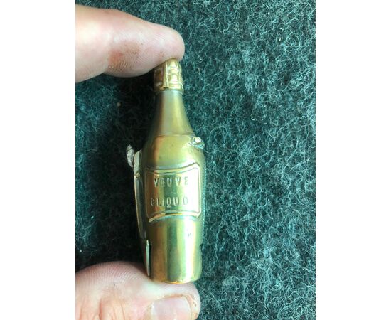 Brass matchbox in the shape of a champagne bottle (Veuve Cliquot) with a cigar-cutter. France     