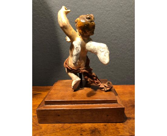 Piccola scultura in terracotta raffigurante angelo.